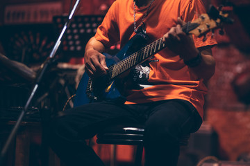 Obraz premium man hand playing guitar acoustic and singing on the stage at night.