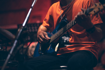 Obraz premium man hand playing guitar acoustic and singing on the stage at night.