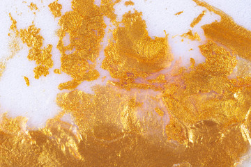 Dry golden acrylic paint on a white background.