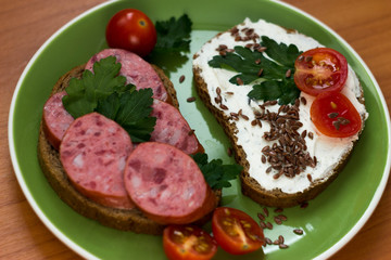 Sausage sandwiches on a plate with tomatoes and herbs