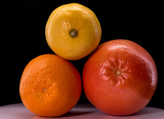 Oranges, grapefruit, lemon on a black background