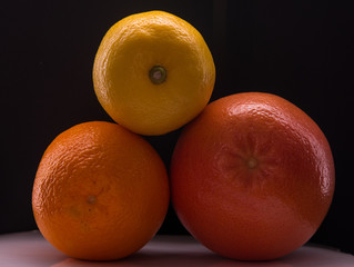 fresh oranges and grapefruit, lemon on a white and black background