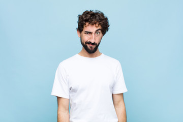 young crazy bearded man feeling confused and doubtful, wondering or trying to choose or make a...