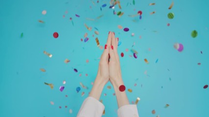 Woman hands clapping applause with festive confetti gesture isolated over blue background in studio. Copy space for advertisement. With place for text or image. Advertising area, mock up.