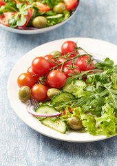 Healthy salad with green olives, cherry tomatoes and rocket. Close up.	