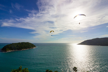 Two paragliders over the small island in the sea