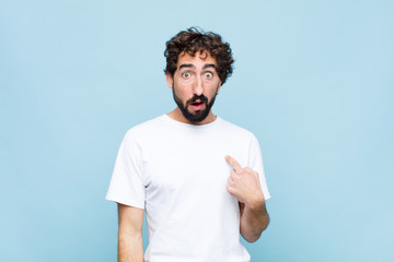 young crazy bearded man feeling confused, puzzled and insecure, pointing to self wondering and...