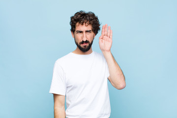 young crazy bearded man looking serious and curious, listening, trying to hear a secret...