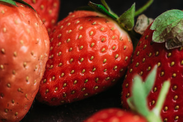 Ripe and juicy strawberry on the dark rustic background. Selective focus. Shallow depth of field.