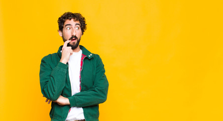 young crazy bearded man with surprised, nervous, worried or frightened look, looking to the side...