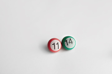a small billiard ball of pink ang green color with the number 11 and number 14 on a white light background
