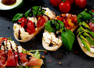 Assorted bruschetta with various toppings.Appetizing bruschetta.Variety of small sandwiches.Mix...