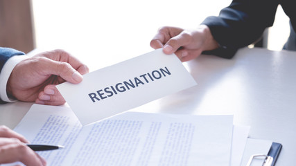 Businessman sending resignation letter to the executive employer boss on desk in order to resign dismiss contract, job placement and vacancies concept.