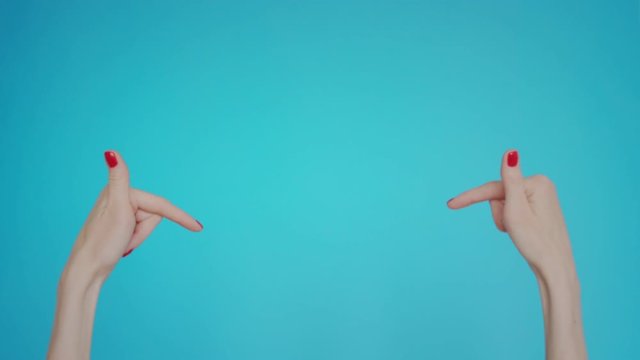 Woman hands pointing on copyspace isolated over pastel blue background in studio. Copy space for advertisement. With place for text or image, promotional content. Advertising area
