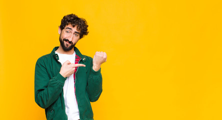 young crazy bearded man looking impatient and angry, pointing at watch, asking for punctuality,...