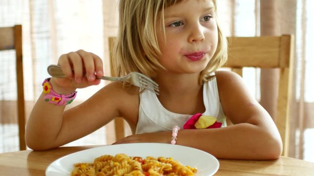 6 year old girl eating spaghetti.