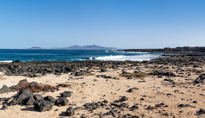 Fototapeta na wymiar Shore of Fuerteventura with Lanzarote Island visible in the distance