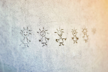 Figures of smiling men drawn on the wall.