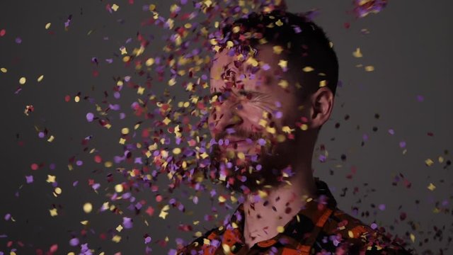 Man is bombarded with colorful confetti - Slow motion