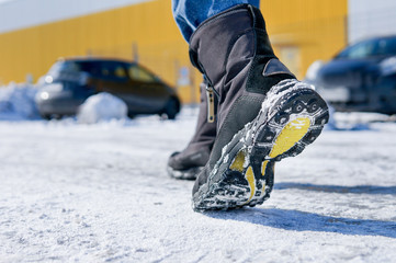 male or female winter boots walking on snowy sleet road	