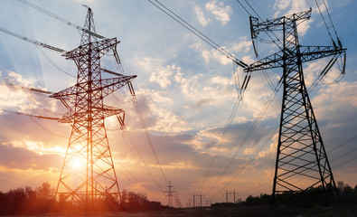 high-voltage power lines at sunset. electricity distribution station. high voltage electric...