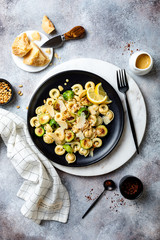 Fresh homemade italian pasta cappelletti with roasted brussels sprouts, pine nuts, parmesan cheese, lemon sauce and red chili flakes