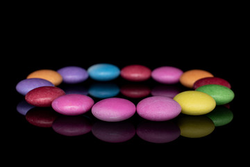 Lot of whole sweet colourful candy circle isolated on black glass