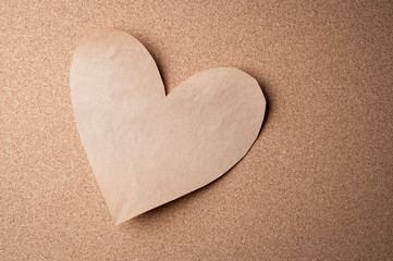 Basic brown paper heart cutout stuck to cork bulletin board for romantic Valentine's Day reminders