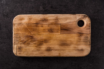 Empty cutting board on black background. Top view