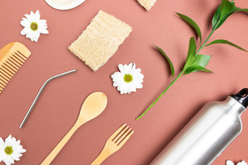 Layout of zero waste accessories for drinking, eating and personal hygiene. Plastic free concept on brown background.
