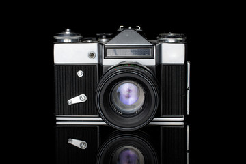 One whole old vintage camera silver black isolated on black glass