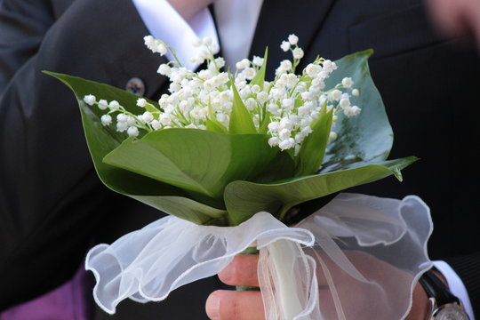 Boquet di mughetto tenuto in mano dallo sposo ad un matrimonio