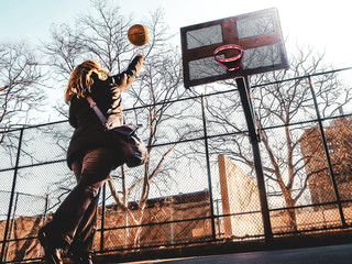 Woman playing basketball in the street