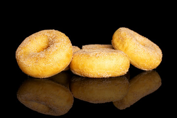 Group of five whole sweet golden mini cinnamon donut isolated on black glass