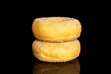Group of two whole sweet golden mini cinnamon donut isolated on black glass