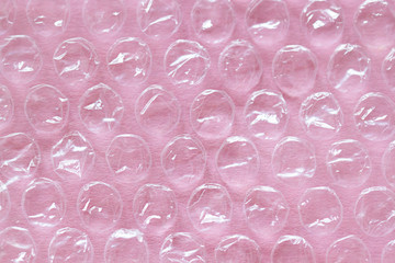 Polyethylene package material close up on the pink background. Abstract macro texture