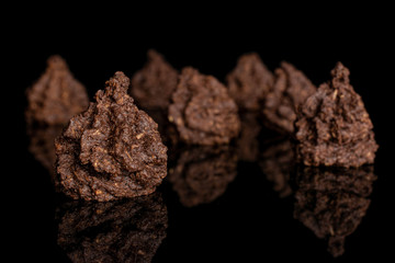 Group of seven whole homemade brown coconut cocoa biscuit isolated on black glass