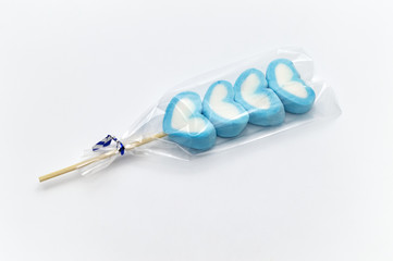 Blue sweet heart shape marshmallow skewed by wood in the clear plastic packaging on white background.