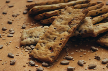 Homemade baking on a wooden table. Sunflower seeds and sesame seeds are scattered on the table. Healthy Eating.