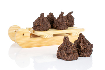 Group of six whole homemade brown coconut cocoa biscuit with wooden sledge isolated on white background