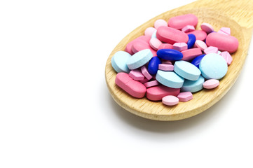 Assorted pharmaceutical medicine pills on wooden spoon. On white background and Copy space.