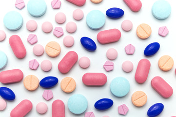 Many scattered Colorful medical pills on white background.