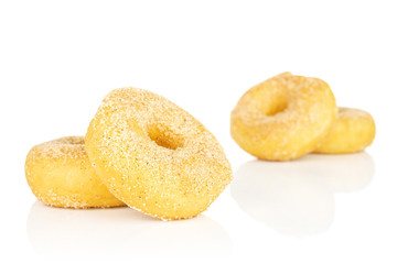 Group of four whole sweet golden mini cinnamon donut in two groups isolated on white background