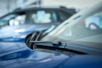 Close up of A windscreen wiper or windshield wiper is a device used to remove rain, snow, ice and debris from a windscreen or windshield. , New cars parked in the showroom