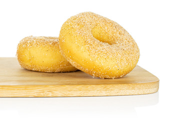 Group of two whole sweet golden mini cinnamon donut on bamboo cutting board isolated on white background