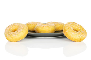 Group of five whole sweet golden mini cinnamon donut on gray ceramic plate isolated on white background