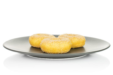 Group of three whole sweet golden mini cinnamon donut on gray ceramic plate isolated on white background