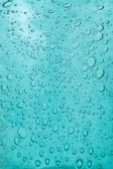 The texture of blue glass with air bubbles inside. A close-up.