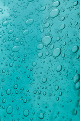 The texture of blue glass with air bubbles inside. A close-up.