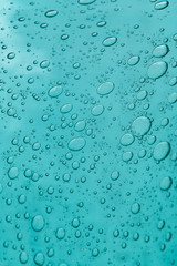 The texture of blue glass with air bubbles inside. A close-up.